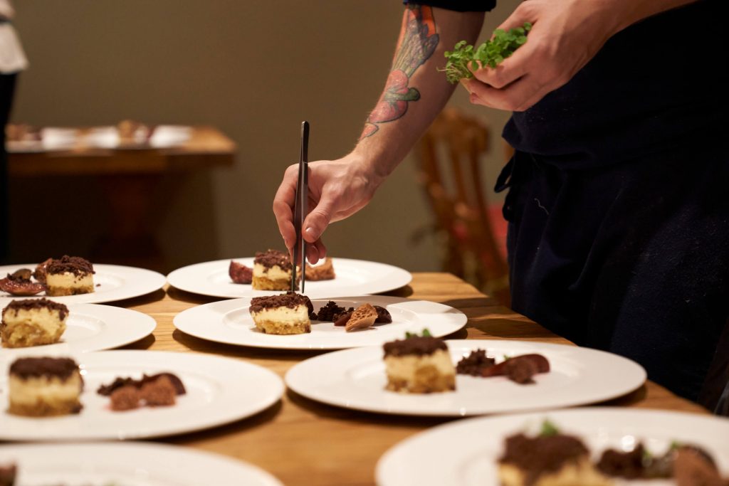 Koch richtet Desserts auf Tellern an - Food-Fotografie