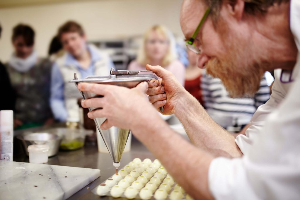 Chocolatier fertigt Pralinen: Momentaufnahme für Foodfotografie