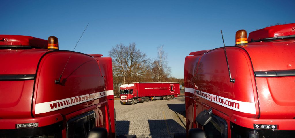 Drei rote Lastkraftwagen in einer Industriefotografie