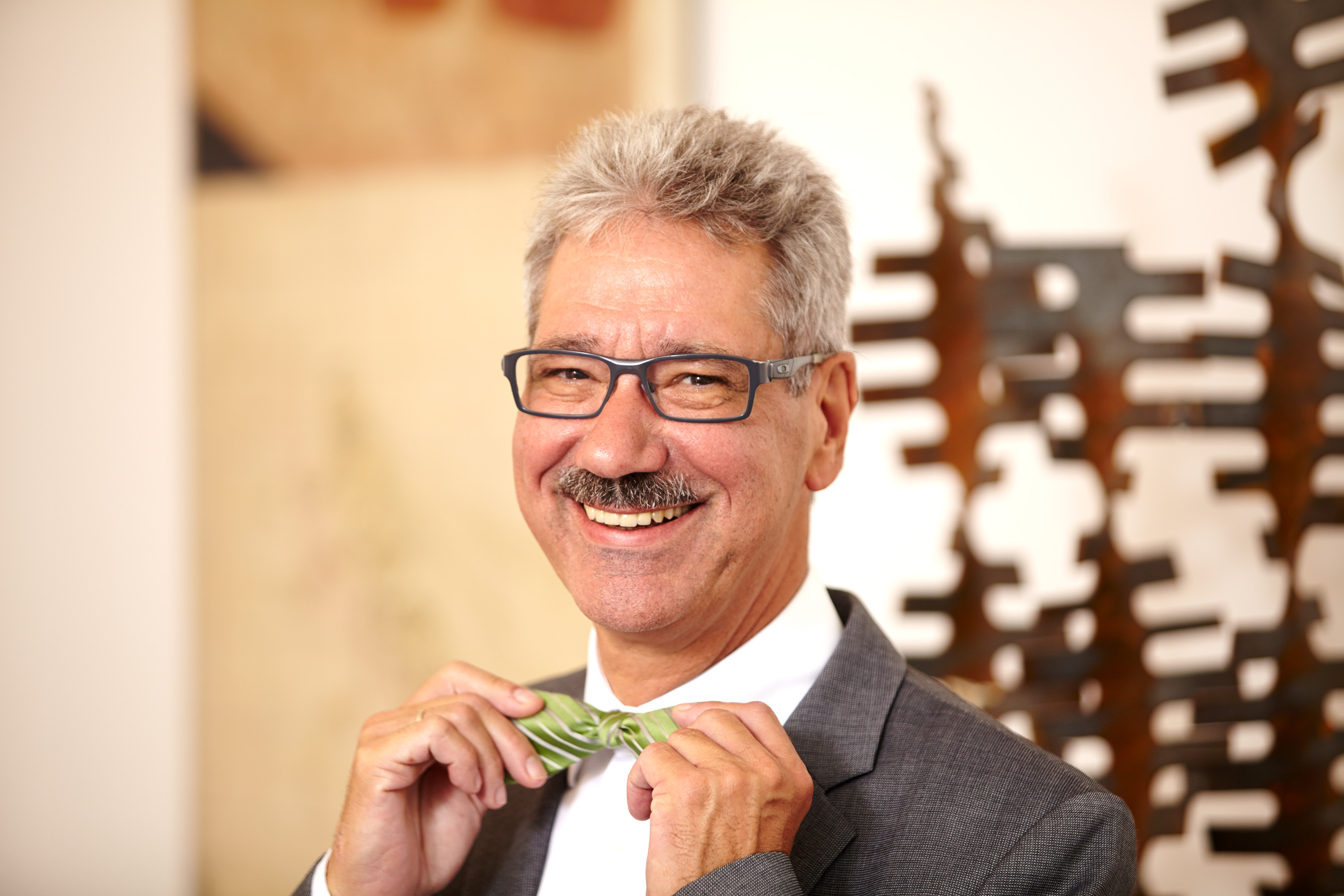 Lächelnder Mann mit grüner Fliege als Portraitfoto