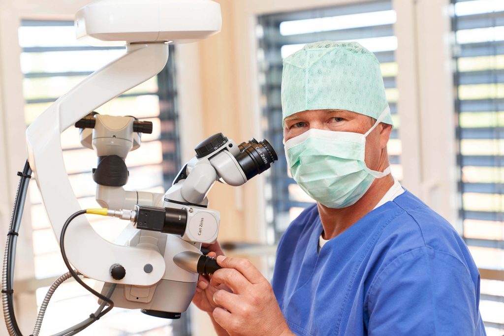 Arzt mit OP-Kleidung arbeitet mit Augenlaser als Businessfoto