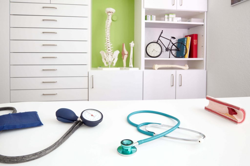 Schreibtisch in Arztpraxis auf dem Stethoskop und Blutdruckmessgerät liegen: Businessfotografie