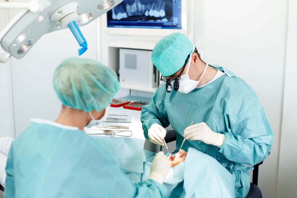 Zahnarzt und Zahnarzthelferin untersuchen einen Patienten: Businessfotografie