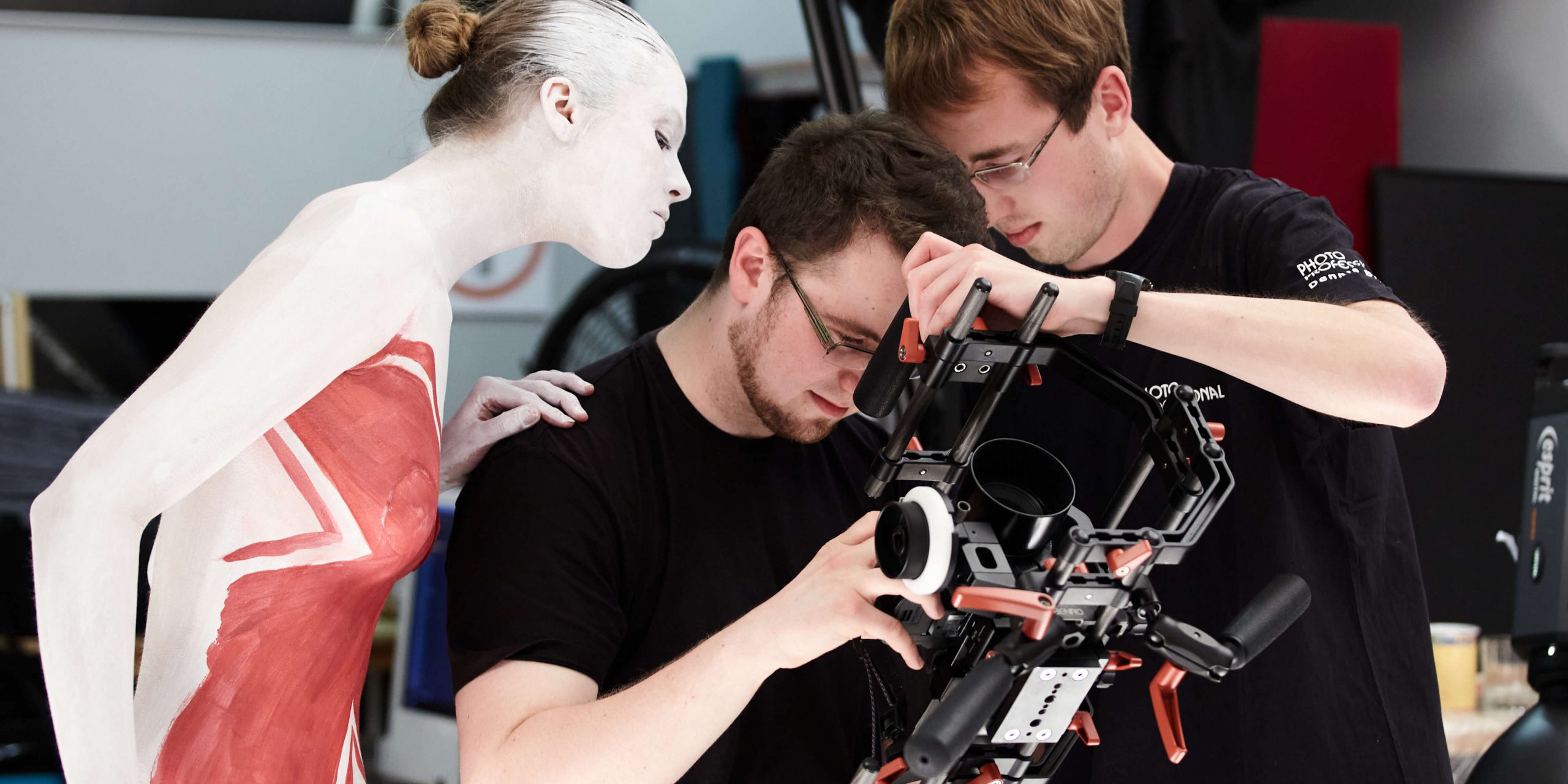 Darsteller und Techniker untersuchen die Videokamera bei einer Produktion